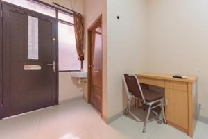 a room with a desk and a chair next to a door at RedDoorz Syariah near Exit Toll Subang in Subang