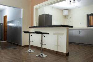 a kitchen with a counter with two stools at Maison entière à vous. 