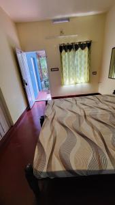 una camera con letto al centro della stanza di GREEN FINCH LAKE VIEW GARDEN RESIDENCY a Cherai Beach