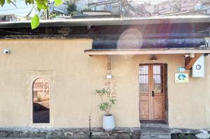een huis met een deur en een plant ervoor bij 嶼民宿 Yu Apartment in Jiufen