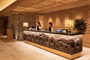 巴奎伊拉－貝萊特的住宿－Hotel MIM Baqueira Luxury & SPA，两名妇女坐在酒店大堂的前台