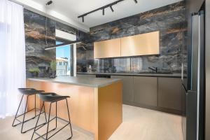 a kitchen with a counter and stools in it at Luxury villa del Sol in Novalja