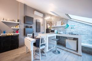 a kitchen with a counter and a table and chairs at Parma Elegant and Sweet Apartments in Parma