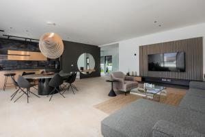 a living room with a couch and a table and chairs at Luxury villa del Sol in Novalja