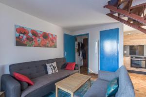 uma sala de estar com um sofá e uma mesa em Les Chardons - Apt duplex vue montagne em Saint-Léger-les-Mélèzes