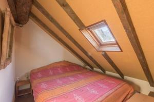 a small bed in a room with a window at Les Chardons - Apt duplex vue montagne in Saint-Léger-les-Mélèzes