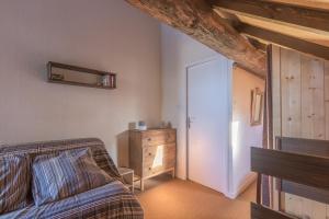 uma sala de estar com um sofá e uma cómoda em Les Chardons - Apt duplex vue montagne em Saint-Léger-les-Mélèzes