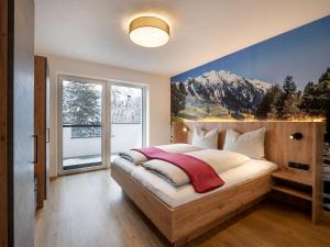 una camera da letto con un letto e un murale di montagna sul muro di Ferienwohnung Klocker a Fügenberg