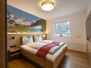 una camera da letto con un letto e un dipinto sul muro di Ferienwohnung Klocker a Fügenberg