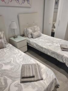 a bedroom with two beds and a mirror at Lazydays in Puerto del Carmen