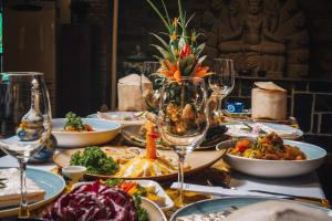 フエにあるピルグリミッジ ヴィレッジ ブティック リゾート & スパのテーブル(食べ物、ワイングラス付)