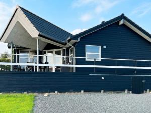 een blauw huis met een zwart dak bij 8 person holiday home in Roslev in Roslev