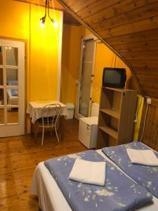 um quarto com uma cama, uma mesa e uma televisão em Sashalom Hotel em Budapeste