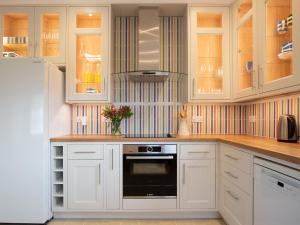 a kitchen with white cabinets and a black oven at Sundown Lodge in Chipping Campden