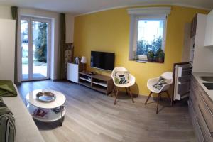 - un salon avec deux chaises et une télévision dans l'établissement Gemütliches Garten-Apartment mit Bergblick, à Murnau am Staffelsee