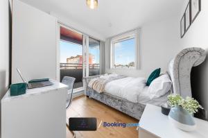 a bedroom with a bed and a desk with a laptop at Two Bedroom Flat By Zen Abodes Short Lets & Serviced Accommodation with Free Wifi & TV Close to Old St in London
