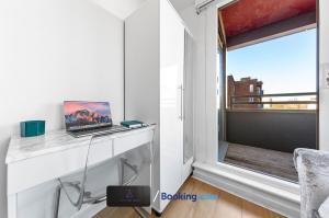 a room with a laptop on a desk next to a window at Two Bedroom Flat By Zen Abodes Short Lets & Serviced Accommodation with Free Wifi & TV Close to Old St in London