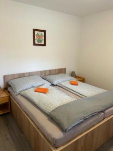 Una cama con dos almohadas naranjas encima. en Polzer CAMPING BÜKFÜRDŐ, en Bük