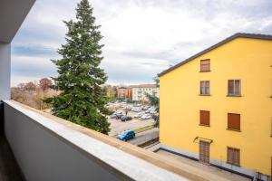 un árbol en un balcón junto a un edificio amarillo en Parma Elegant and Sweet Apartments, en Parma