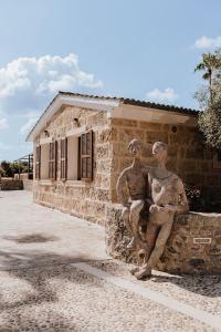 une statue de deux hommes assis sur le côté d'un bâtiment dans l'établissement Sa Talaia Blanca, à Muro