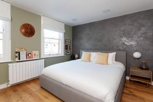 a bedroom with a large white bed and green walls at Veeve - Exalted Living in London
