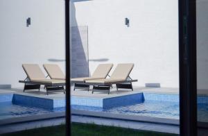 two lounge chairs sitting next to a swimming pool at Hadeer Chalet in Riyadh