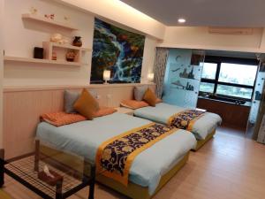een slaapkamer met 2 bedden en een raam bij Haiyu Island Spring Apartment in Toucheng