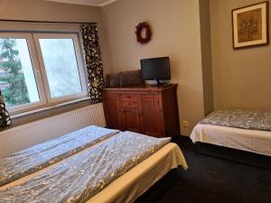 a bedroom with two beds and a tv on a dresser at Wigwam Apartament 5-osobowy in Sopot