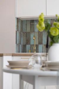 a kitchen counter with a sink and a mirror at Elite Apartments Mariacka Premium in Gdańsk