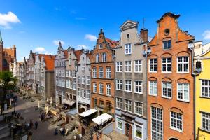 a city street with buildings and people walking around at Elite Apartments Mariacka Premium in Gdańsk