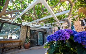 a porch with purple flowers in front of a house at Hotel Saraceno in Giglio Porto