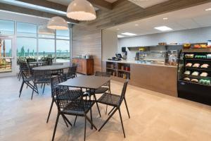 a restaurant with tables and chairs and a kitchen at SpringHill Suites by Marriott Panama City Beach Beachfront in Panama City Beach