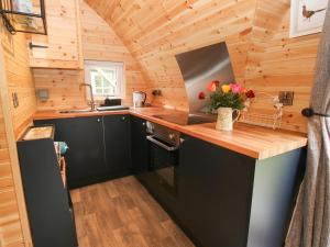 a kitchen in a tiny house with wooden walls at The Pod in Shrewsbury