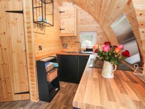 a kitchen in a tiny house with flowers on a counter at The Pod in Shrewsbury