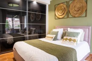 une chambre avec un grand lit avec des oreillers dessus dans l'établissement Appartement Cosy Jardin et Terrasse, à Strasbourg