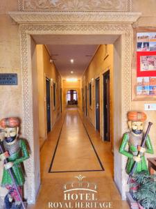 un pasillo en un hotel con dos estatuas en la pared en Hotel Royal Heritage, en Jaisalmer