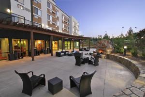 a patio with chairs and tables in front of a building at Courtyard by Marriott Raleigh North/Triangle Town Center in Raleigh