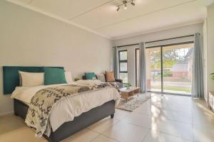 a bedroom with a large bed and a sliding glass door at Poppy Rentals in Fourways