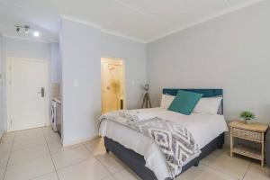 a bedroom with a large bed with white walls at Poppy Rentals in Fourways