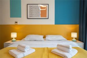 ein Schlafzimmer mit einem Bett mit zwei Handtüchern darauf in der Unterkunft izzzilife Mint in Dubai