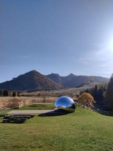 uma cúpula num campo com montanhas ao fundo em Villa Zoe - Suite con Sauna em Margone