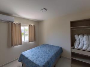 een slaapkamer met een bed en een raam bij Residencial Brisa do Mar 2 in Bombinhas