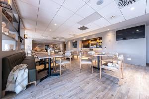 a restaurant with tables and chairs in a room at Estival Caribou Apartments in Pas de la Casa