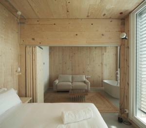 a bedroom with a bed and a tub and a couch at Hotel Amiuka in O Pedrouzo