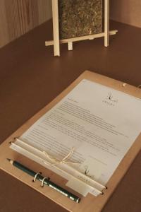 a piece of paper with two pens on a table at Hotel Amiuka in O Pedrouzo