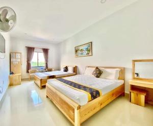 a hotel room with two beds and a piano at Biển Đông Hotel Đảo Phú Quý in Cu Lao Thu