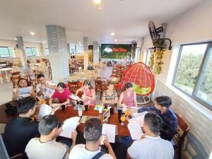a group of people sitting around a table in a restaurant at Biển Đông Hotel Đảo Phú Quý in Cu Lao Thu