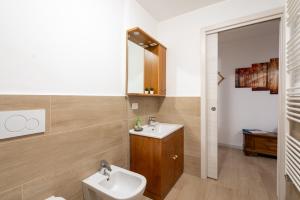 bagno con lavandino, servizi igienici e specchio di Asiago Centro - Comodissimo Appartamento al Piano Terra ad Asiago
