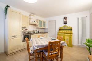 a kitchen with a table and chairs and a kitchen with a stove at Piano Terra in centro - A due passi da tutto in Asiago