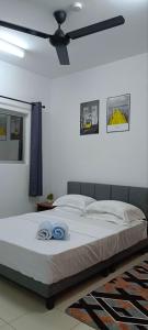 1 dormitorio con 1 cama con 2 toallas azules en AtSky KLIA - One Room Apartment en Kampong Bekoh